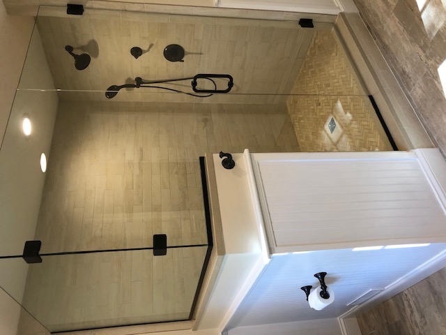 Finished walk-in shower with custom tile and frameless glass enclosure