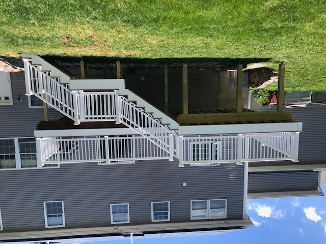 Elevated deck with white vinyl railing and staircase